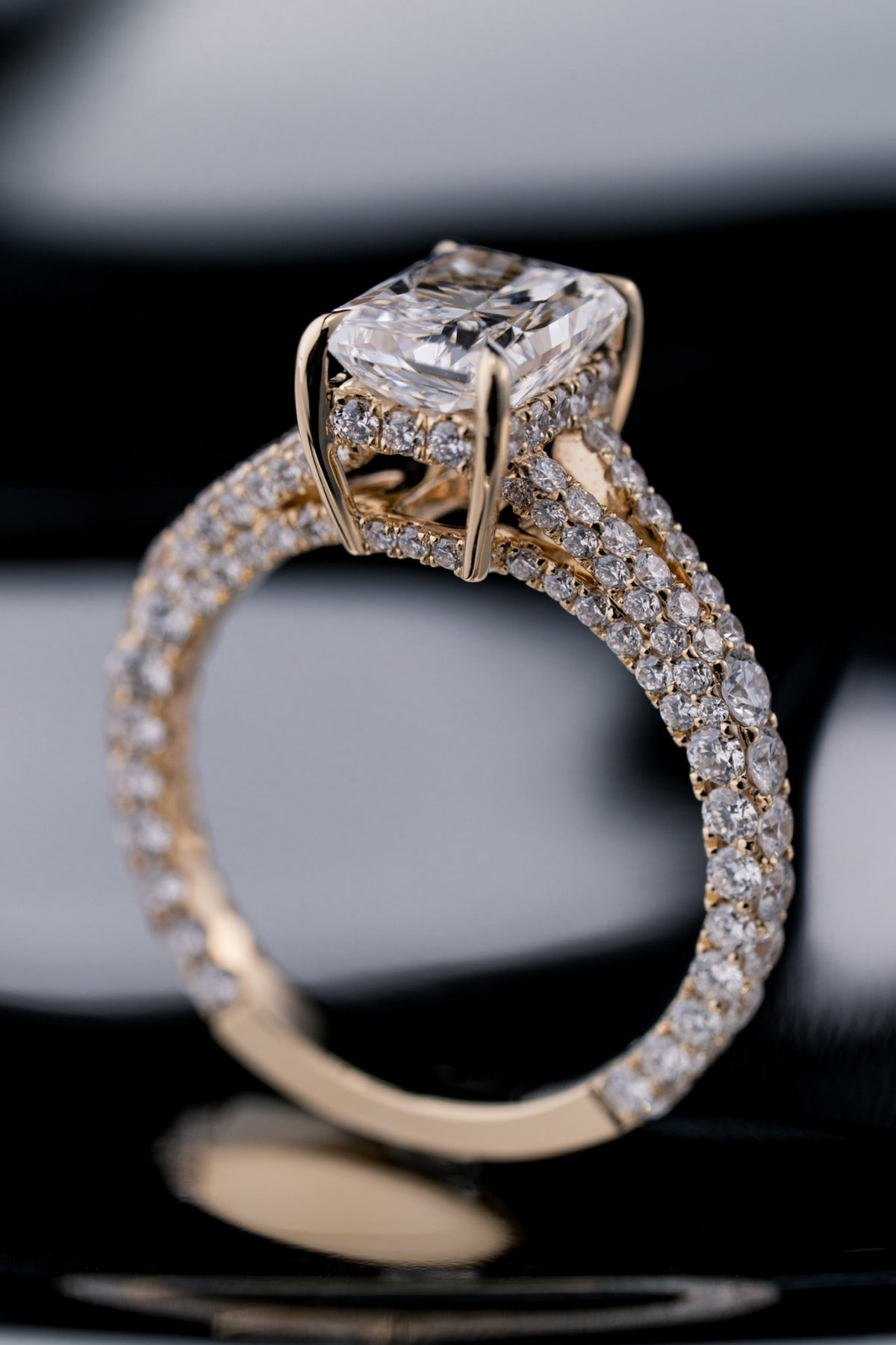 Close three-quarter view of a custom radiant-cut diamond engagement ring by RIAZ