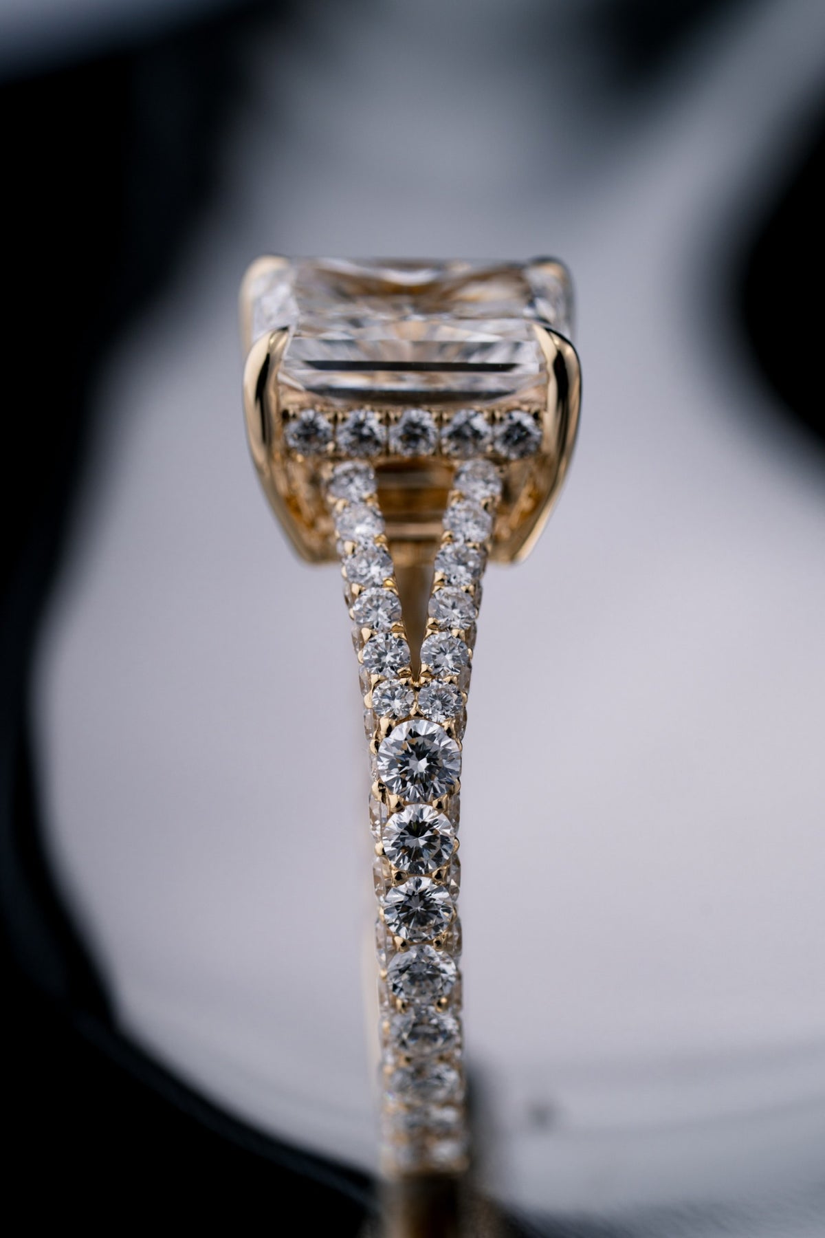 Side profile and split pavé detail of a custom radiant-cut diamond engagement ring by RIAZ