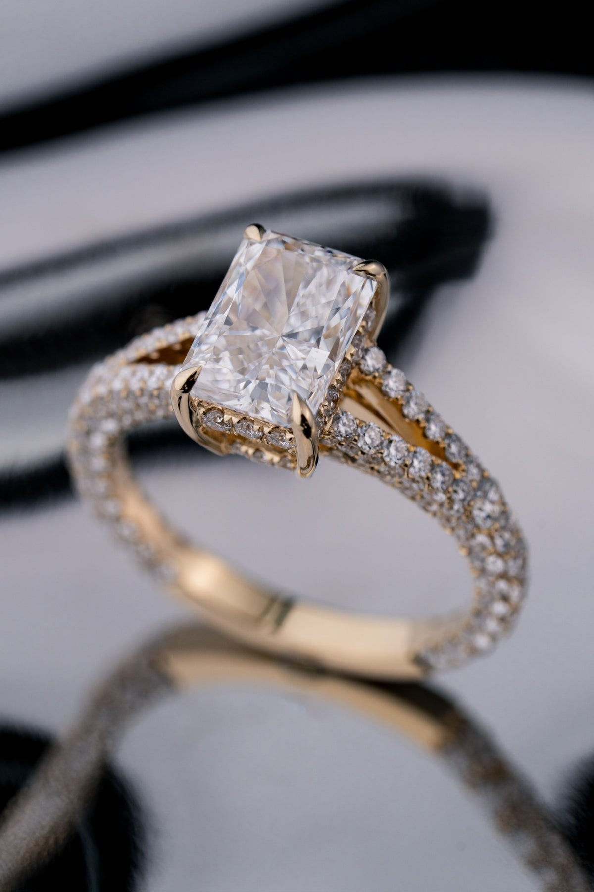Angled front view of a custom radiant-cut diamond engagement ring by RIAZ